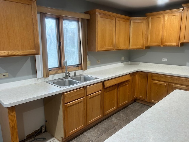 18502 River Rd, Hazel Crest, IL 60429 - kitchen featuring a sink, light countertops, brown cabinets, and dark tile patterned flooring