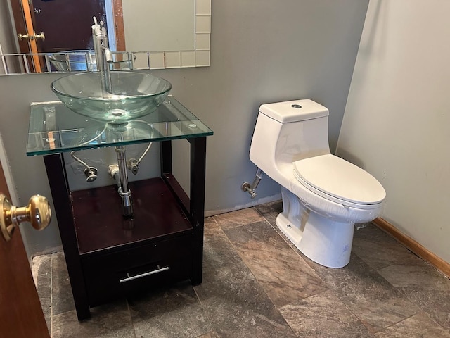 18502 River Rd, Hazel Crest, IL 60429 - bathroom featuring toilet, stone finish floors, vanity, and baseboards