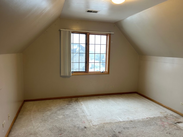 bonus room with light carpet and vaulted ceiling