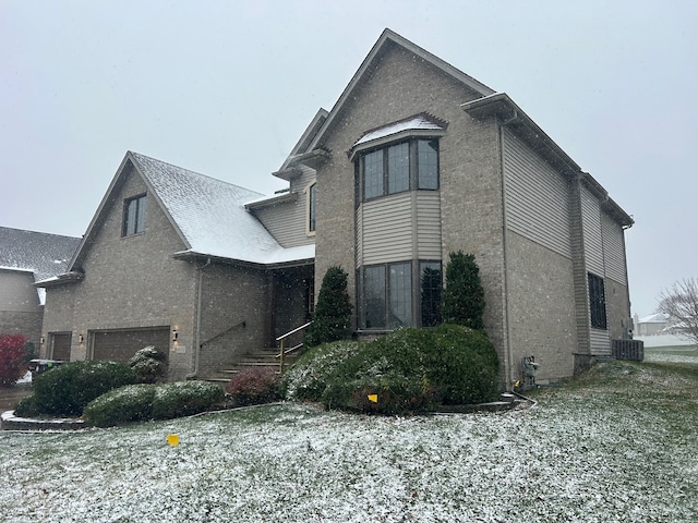 view of side of property with a garage and central AC