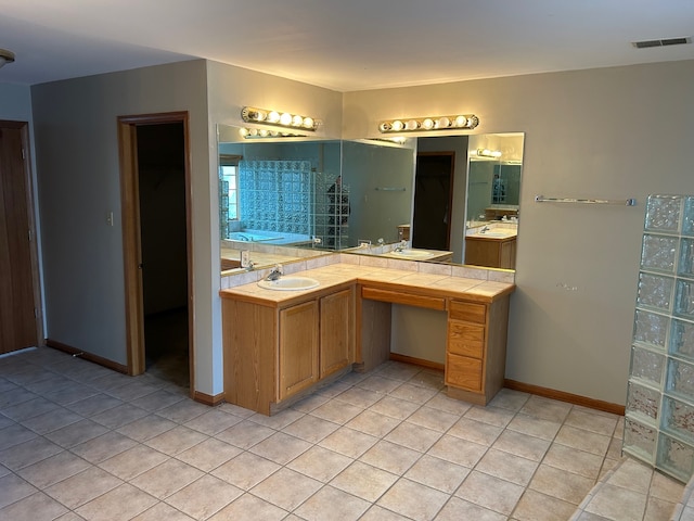 bathroom with tile patterned flooring, vanity, and a bath