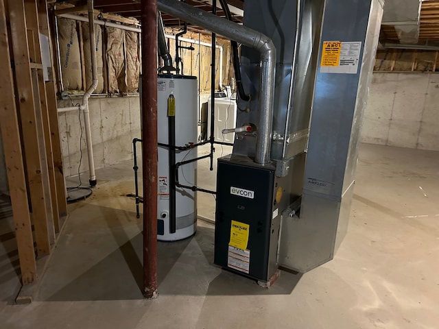 utility room with gas water heater, washer / clothes dryer, and heating unit