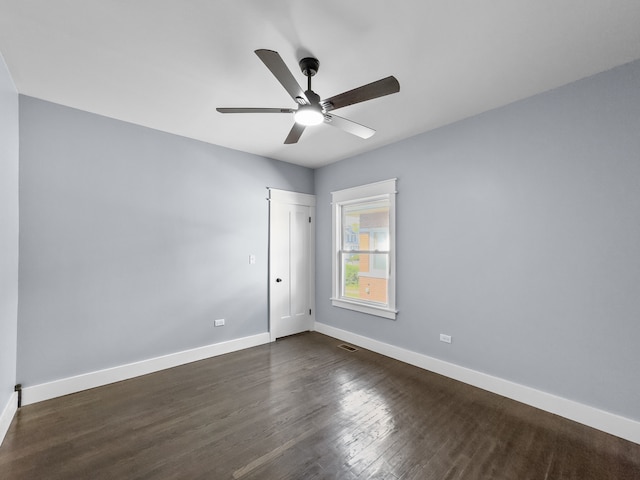 spare room with ceiling fan and dark wood-type flooring