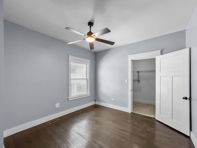 unfurnished bedroom with ceiling fan, a closet, and dark wood-type flooring