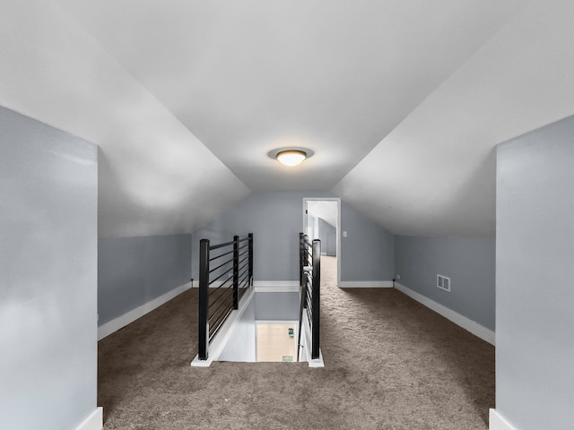 additional living space with dark carpet and lofted ceiling