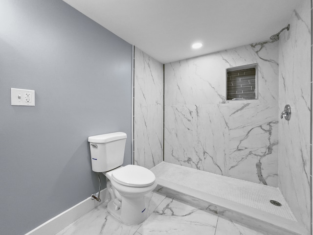 bathroom with a tile shower and toilet