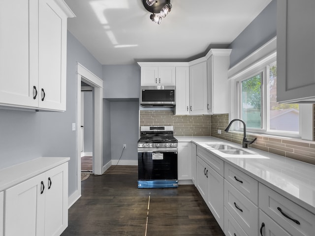 kitchen featuring sink, dark hardwood / wood-style floors, backsplash, white cabinets, and range