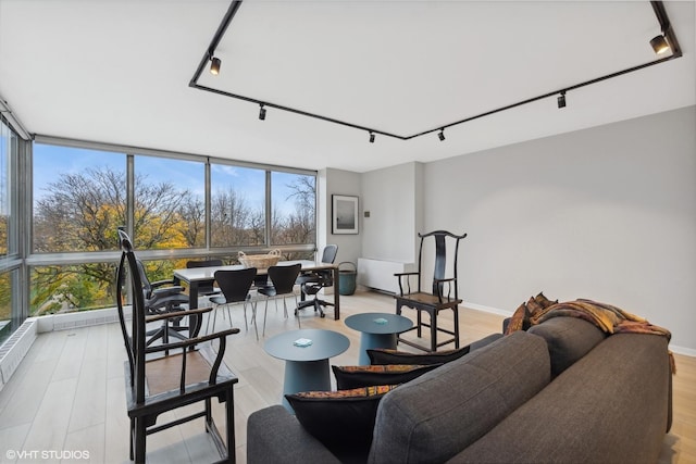 living room with expansive windows, rail lighting, and plenty of natural light