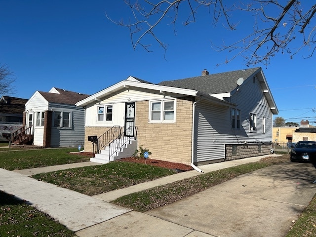 bungalow-style home with a front yard