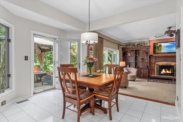 carpeted dining room featuring ceiling fan, crown molding, and a healthy amount of sunlight