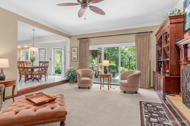 living room featuring ceiling fan, crown molding, and light colored carpet