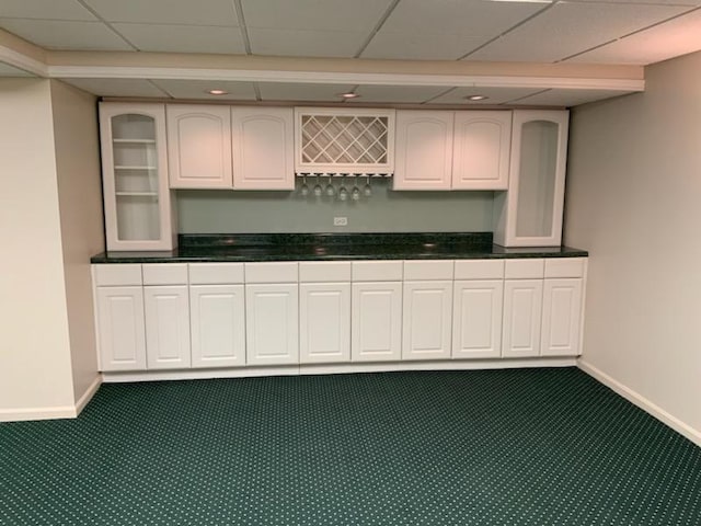 kitchen with white cabinets, carpet flooring, and a drop ceiling