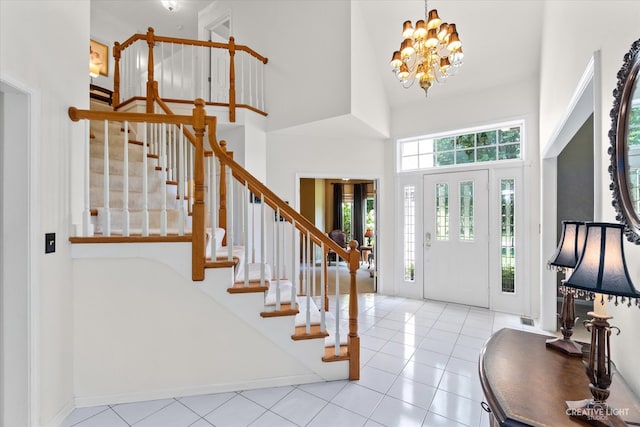 tiled entrance foyer with a chandelier and a high ceiling