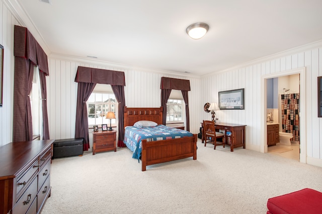 bedroom with crown molding, light carpet, and ensuite bath