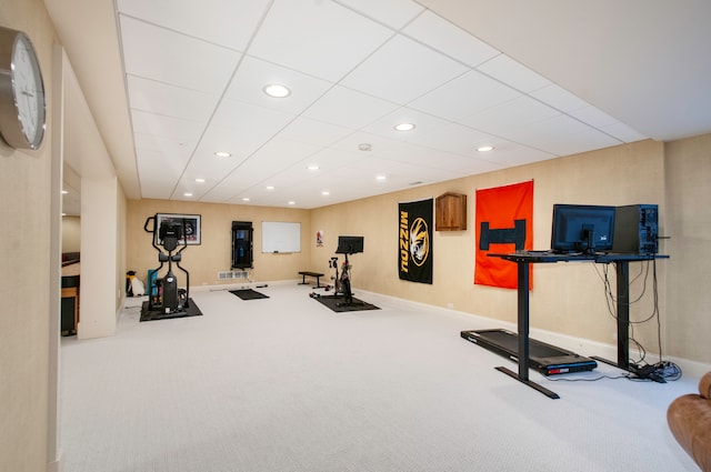 exercise room featuring carpet flooring and a paneled ceiling