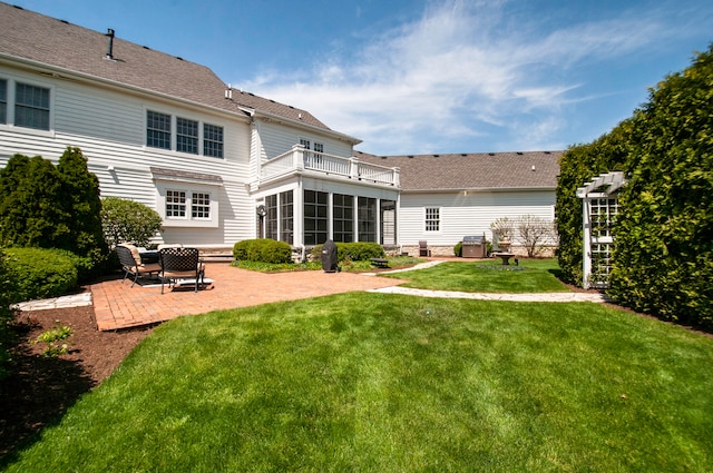 back of house with a lawn, a patio area, and a balcony