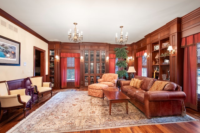 living room featuring hardwood / wood-style floors, a notable chandelier, and crown molding