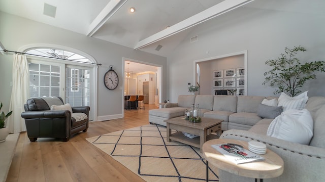 living room featuring beam ceiling, high vaulted ceiling, and light wood-type flooring