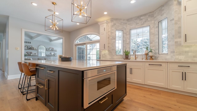 kitchen featuring white cabinetry, decorative light fixtures, and a kitchen island