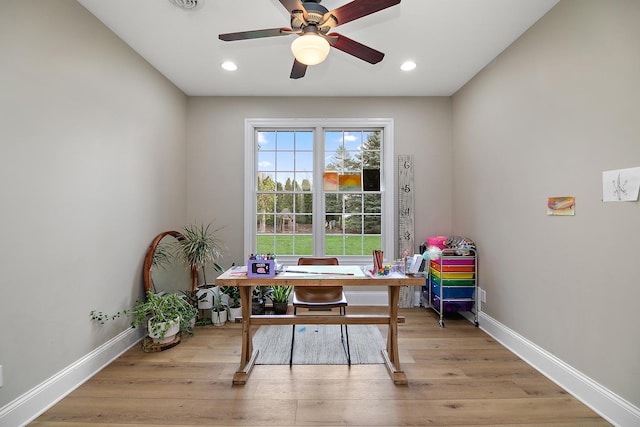 home office with light hardwood / wood-style flooring and ceiling fan