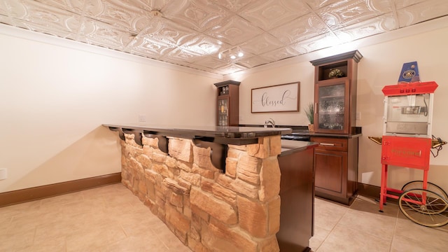 bar featuring light tile patterned flooring and crown molding