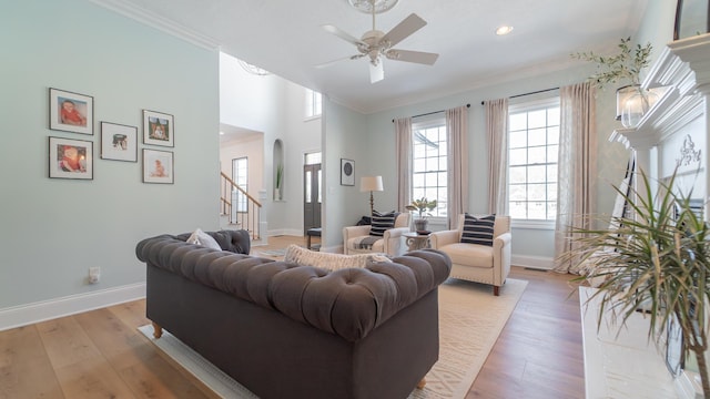 living room featuring crown molding, light hardwood / wood-style flooring, and ceiling fan