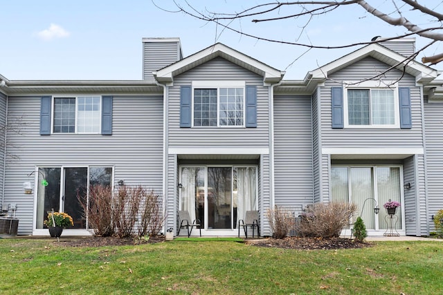 rear view of house featuring a yard