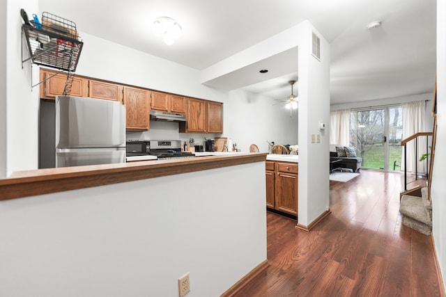 kitchen featuring kitchen peninsula, ceiling fan, stainless steel appliances, and dark hardwood / wood-style floors