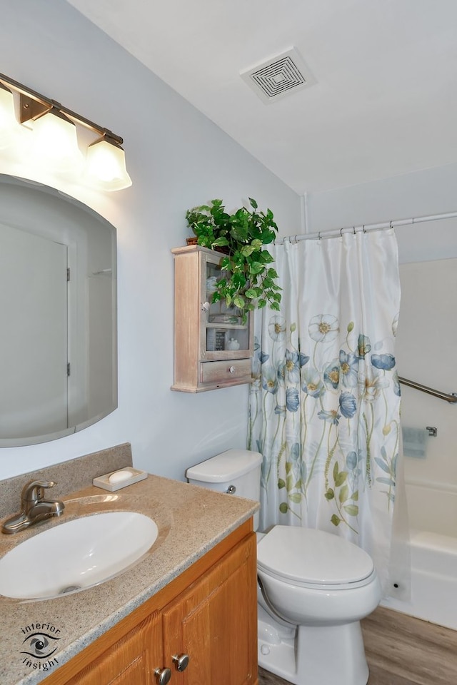 full bathroom featuring wood-type flooring, vanity, toilet, and shower / bath combo with shower curtain