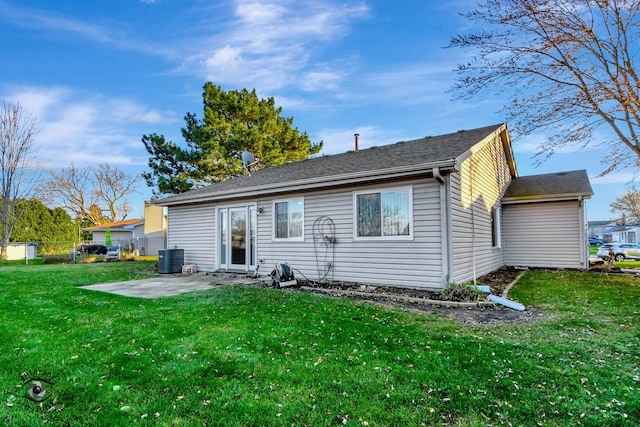 rear view of house with central AC unit, a yard, and a patio