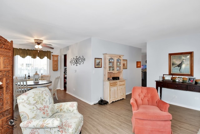 living room featuring ceiling fan and light hardwood / wood-style floors