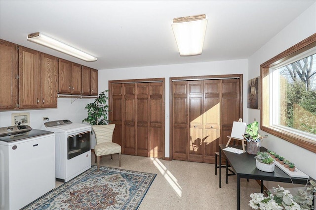 washroom with washing machine and clothes dryer and cabinets