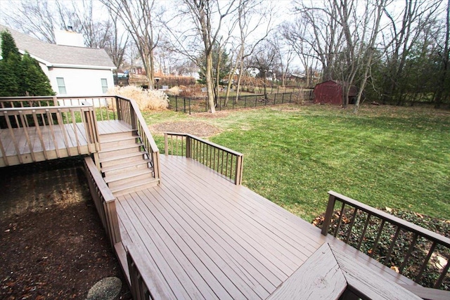 wooden terrace featuring a lawn and a shed