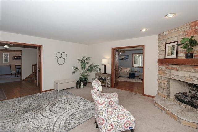 living room with light carpet and a stone fireplace