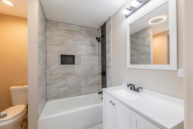 full bathroom with vanity, tiled shower / bath, and toilet