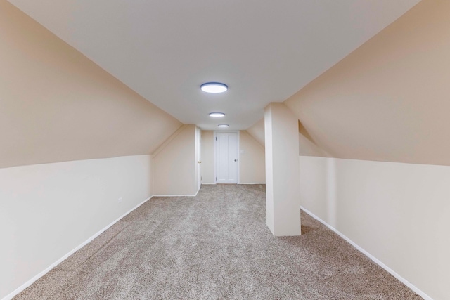 bonus room with light colored carpet and lofted ceiling