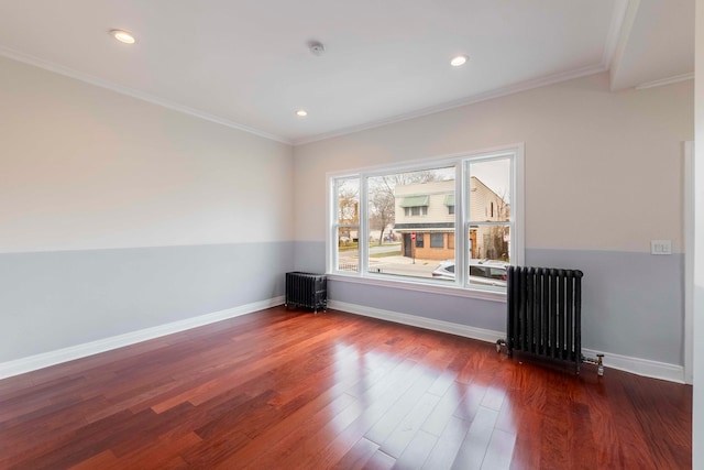 spare room with radiator, dark hardwood / wood-style flooring, and ornamental molding