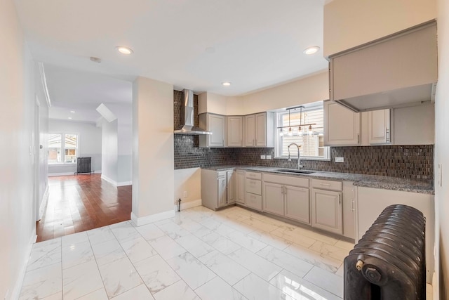 kitchen featuring backsplash, sink, wall chimney exhaust hood, and light hardwood / wood-style floors