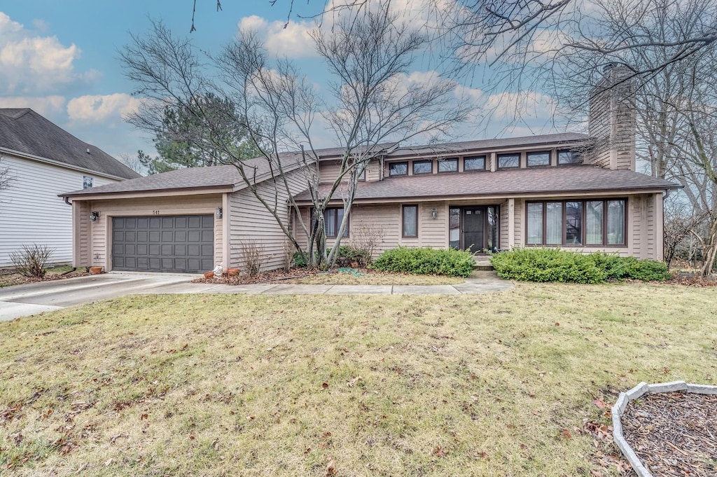 view of front of property with a front yard and a garage