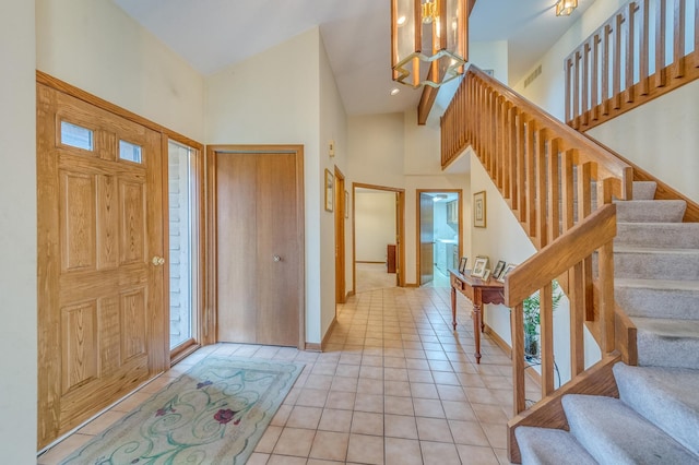 tiled foyer entrance with a chandelier and a high ceiling