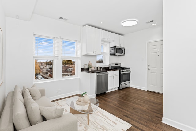 kitchen featuring sink, white cabinets, dark hardwood / wood-style floors, and appliances with stainless steel finishes