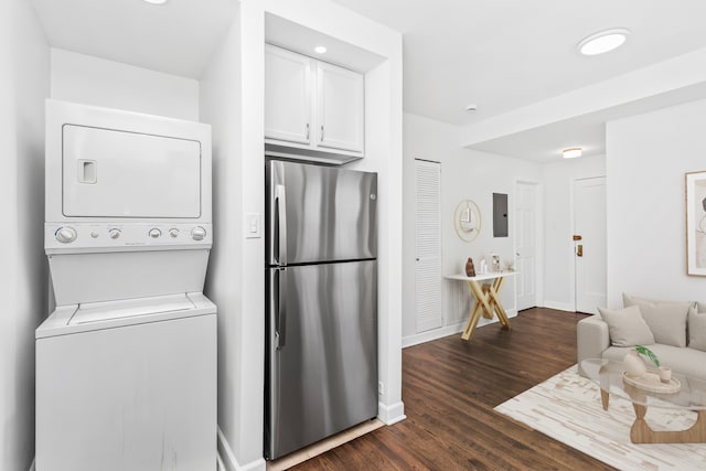 washroom featuring dark hardwood / wood-style floors and stacked washer / dryer