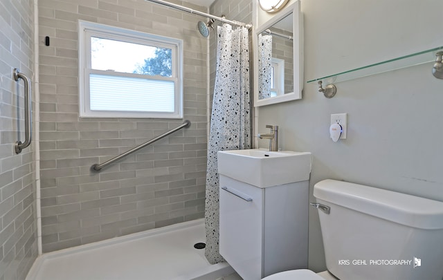 bathroom featuring a shower with shower curtain, vanity, and toilet