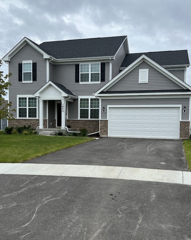 view of front of house with a front yard and a garage