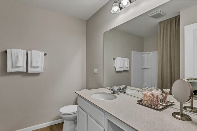 bathroom featuring a shower, hardwood / wood-style floors, vanity, and toilet