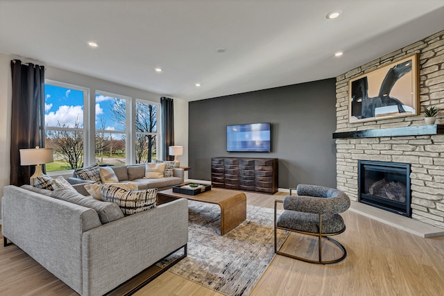 living room with light wood-type flooring and a fireplace