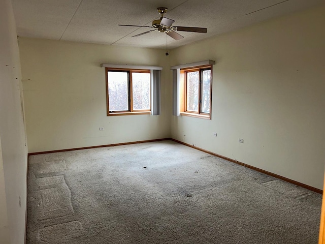 carpeted empty room featuring ceiling fan and a textured ceiling