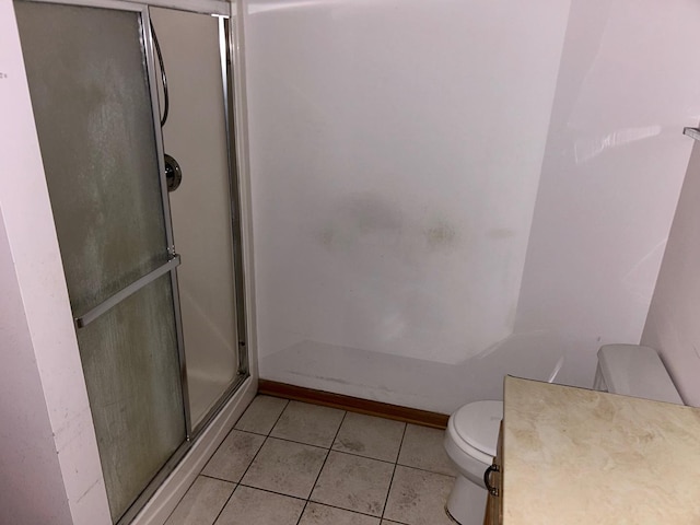 bathroom with tile patterned floors, toilet, and a shower with shower door