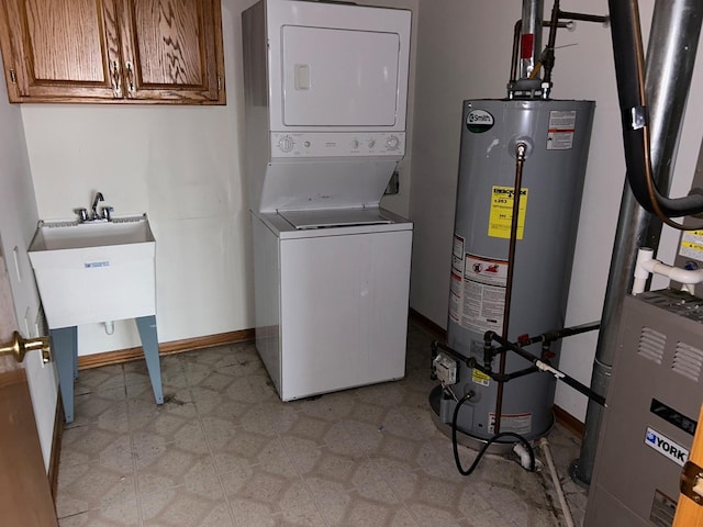 laundry room with water heater and stacked washer and clothes dryer