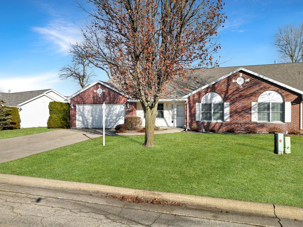 ranch-style home with a front lawn and a garage